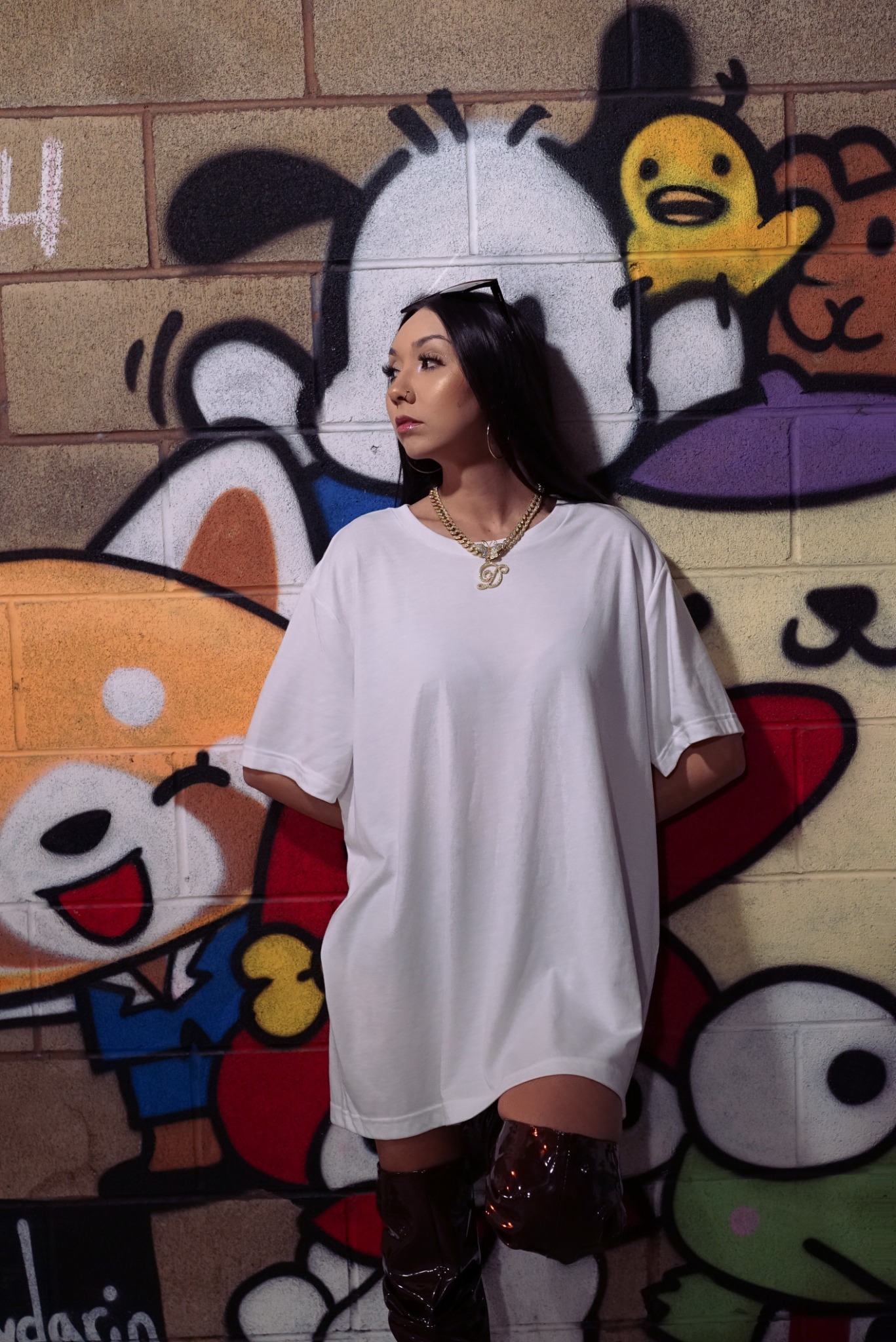 Fashion portrait in an oversized white shirt against a graphic mural