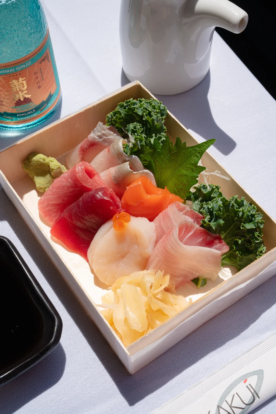 Colorful sashimi with sake in a Kakui presentation box